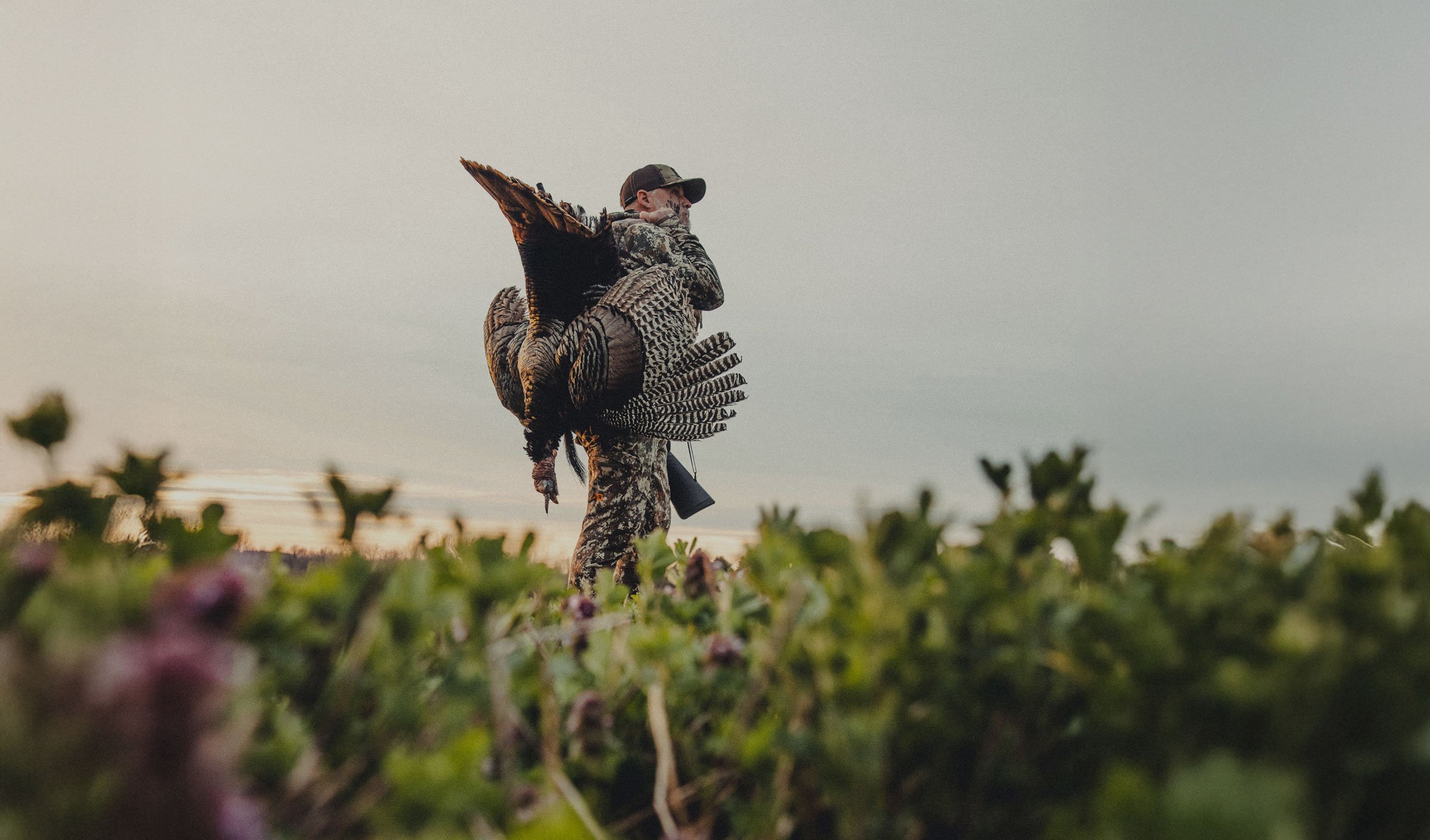 A man in gray boots ascending a tree