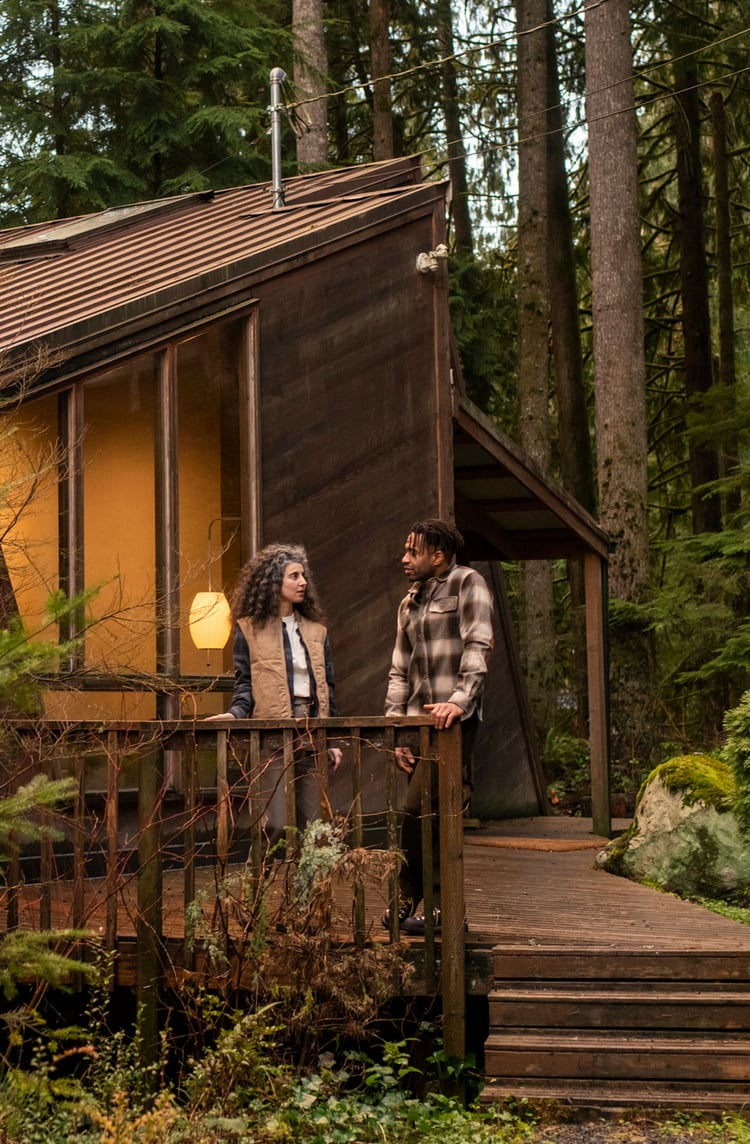 a man and woman on the porch of a cabin
