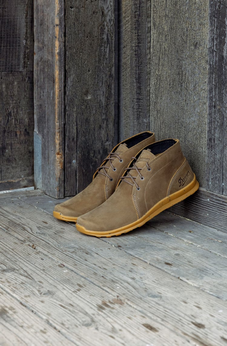 a pair of casual shoes leans against a house
