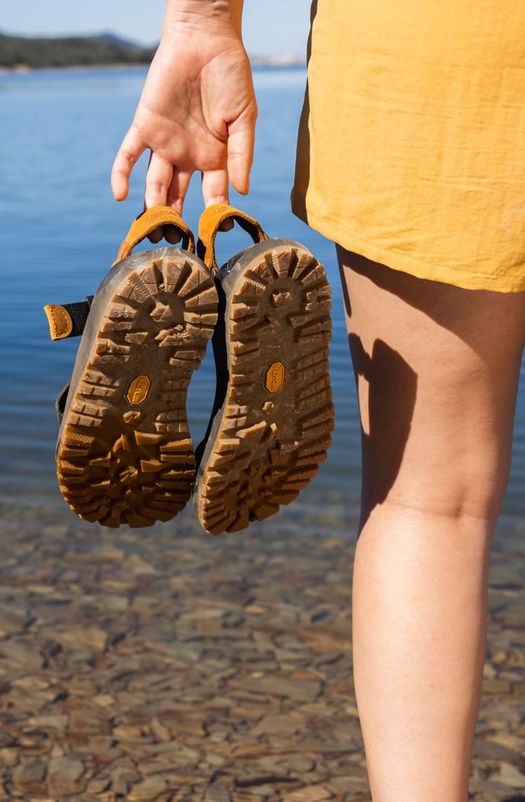 A of sandals being held by the lake