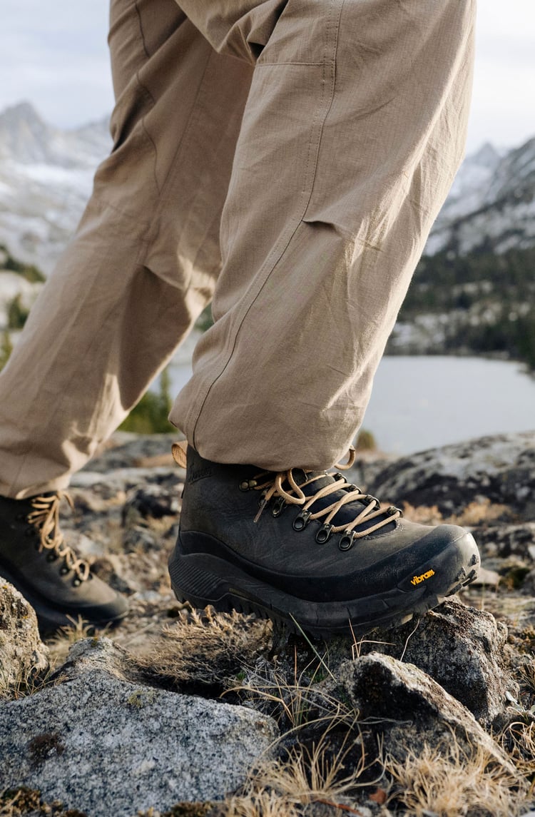 a couple hiking in the mountains wearing ankle high boots