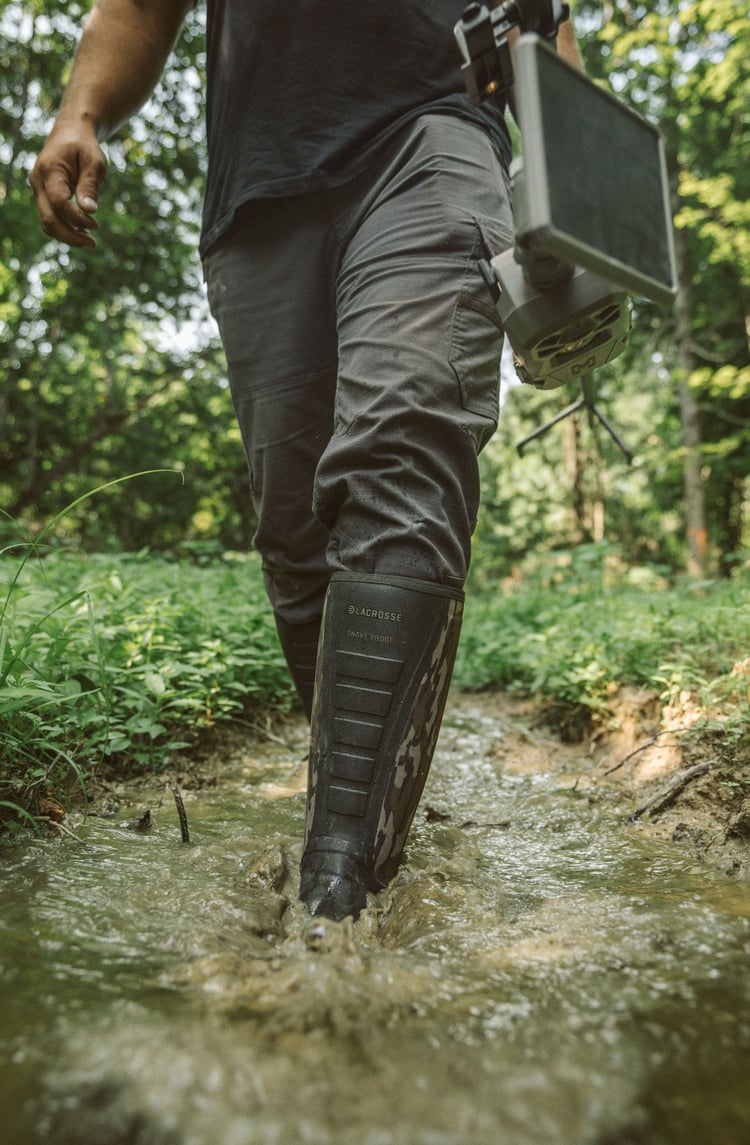 A man in gray boots ascending a tree