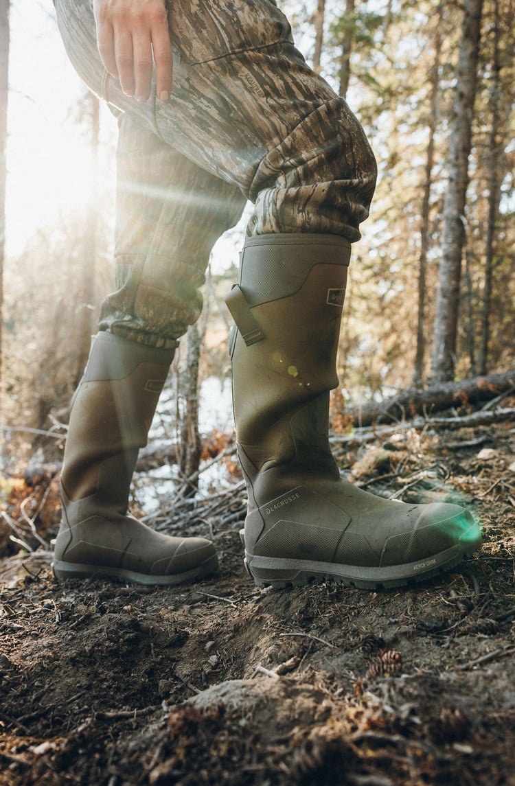 A man in gray boots ascending a tree