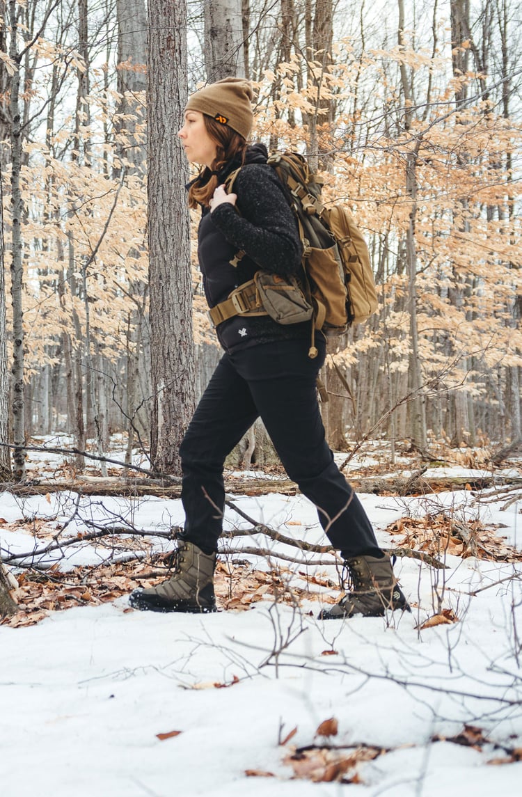 A man in gray boots ascending a tree