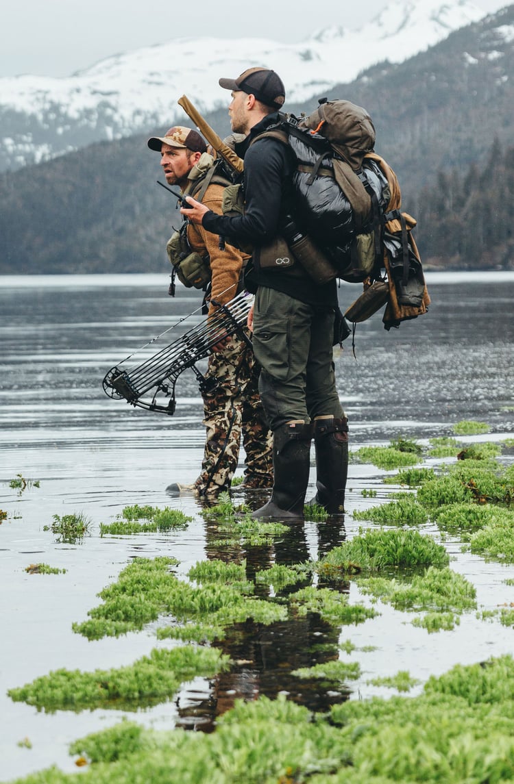 A man in gray boots ascending a tree