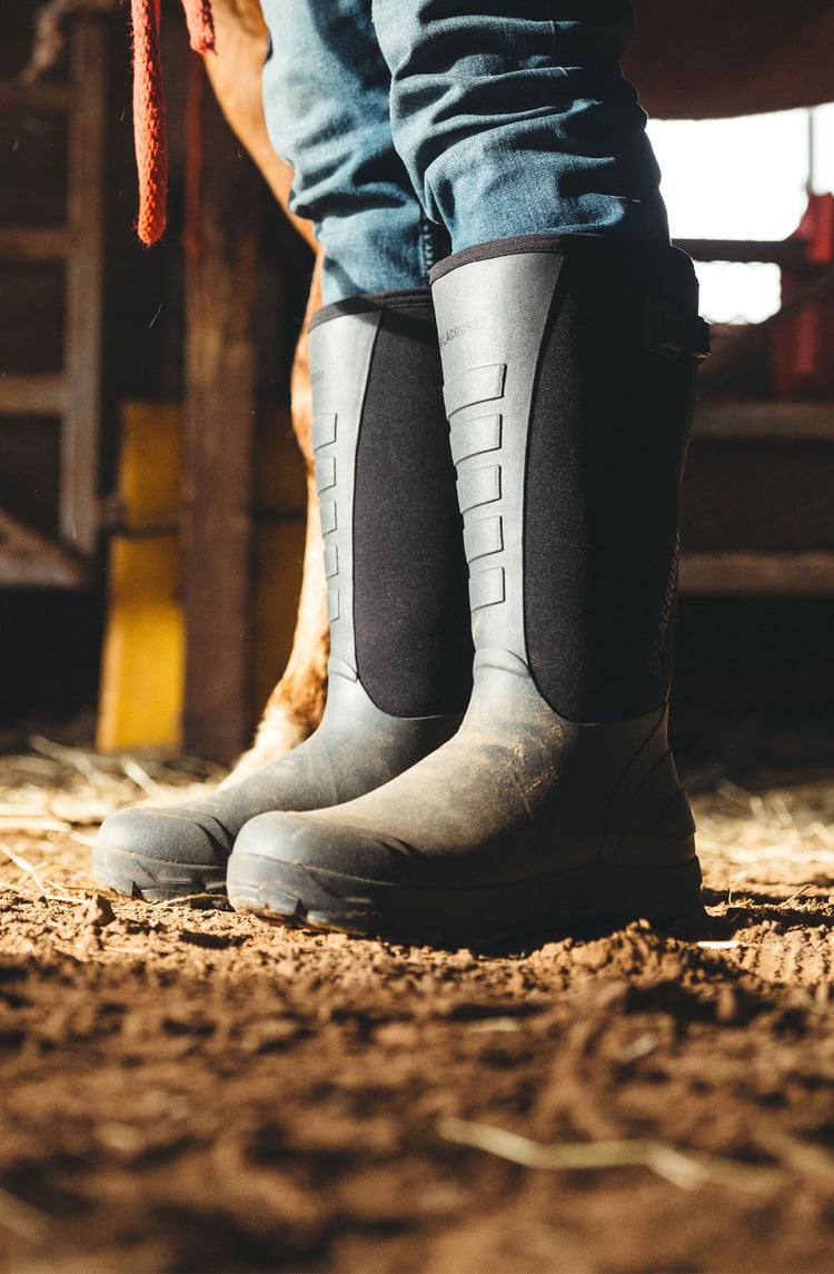 A man in gray boots ascending a tree