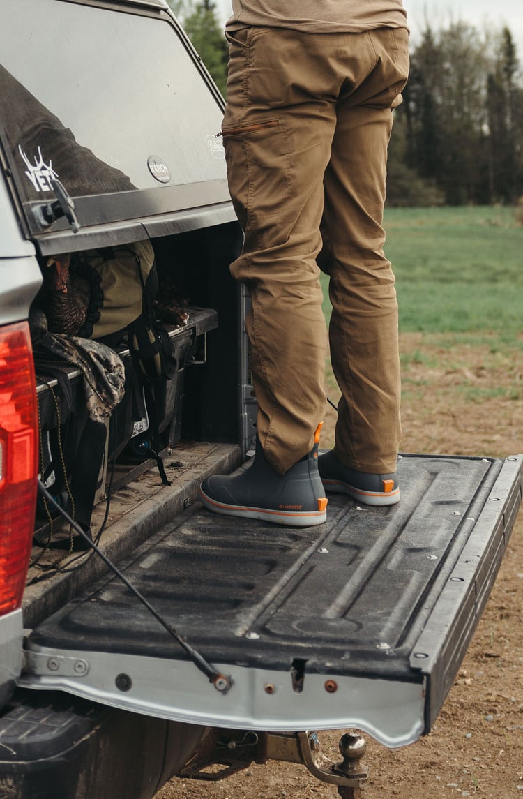 A man in gray boots ascending a tree