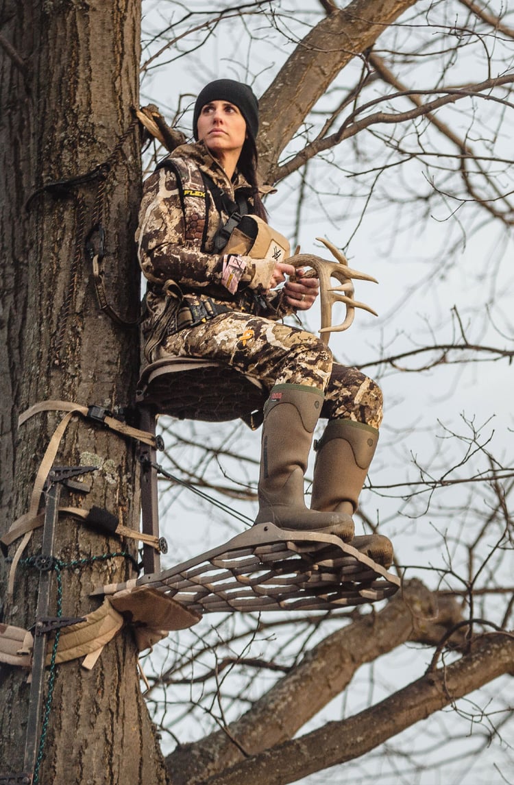 A man in gray boots ascending a tree