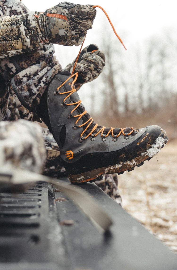 A man in gray boots ascending a tree