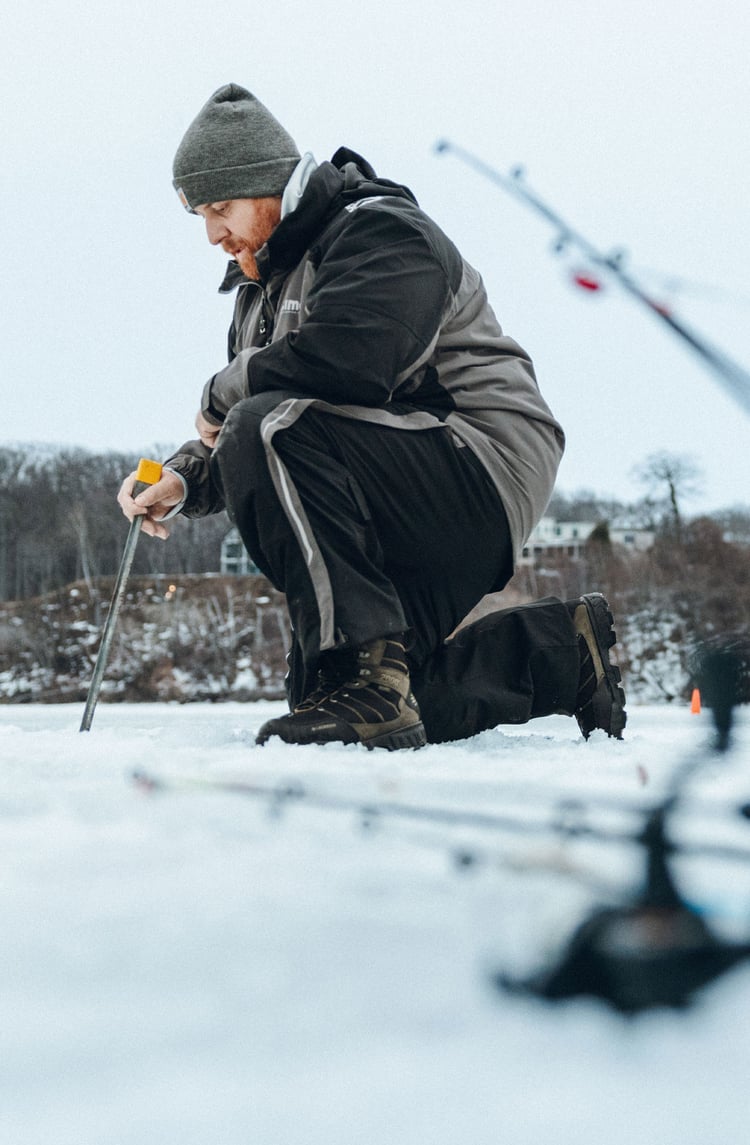 A man in gray boots ascending a tree