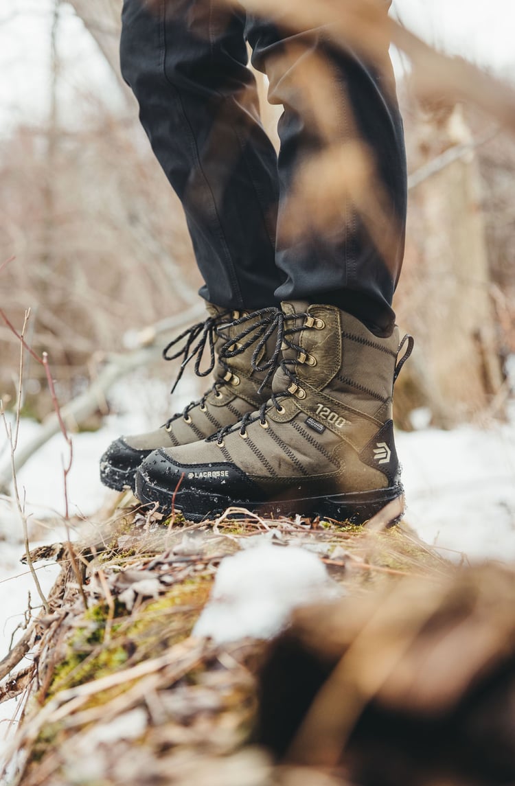 A man in gray boots ascending a tree