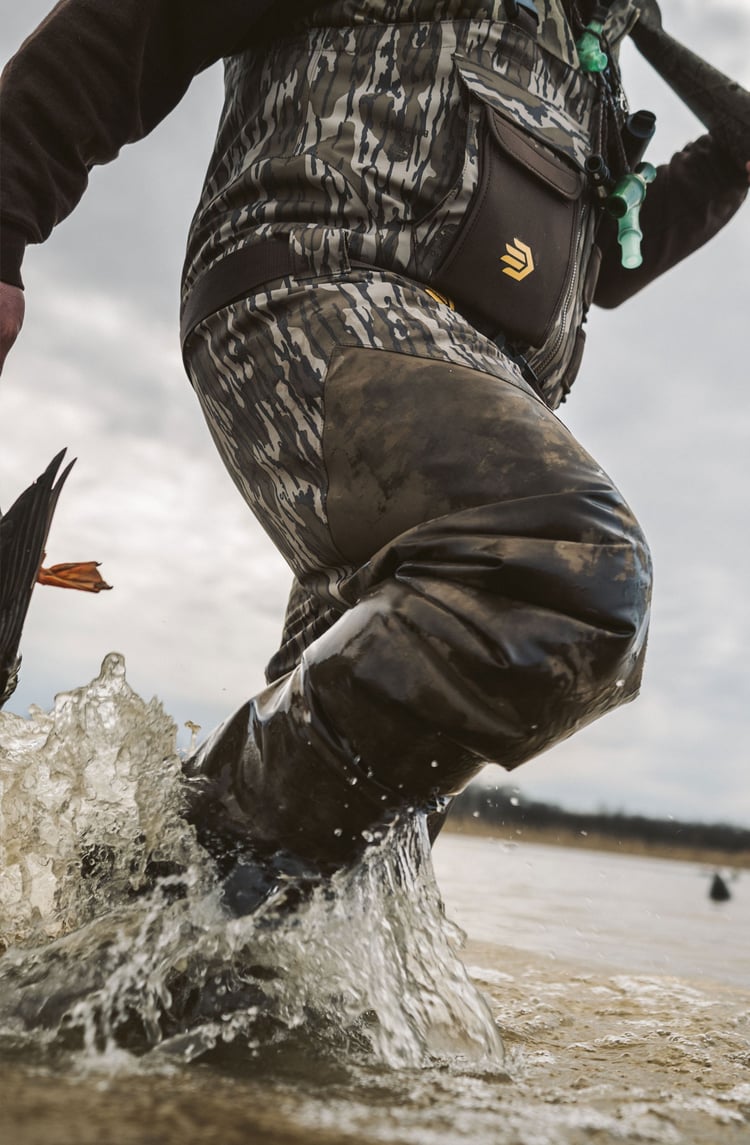 A man in gray boots ascending a tree