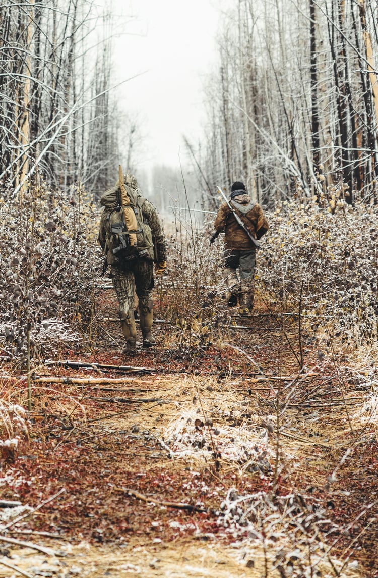 a group of hunters trekking through the snow in insulated rubber boots