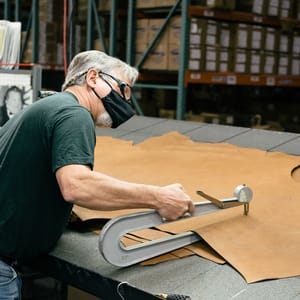 A dark brown leather boot shown in profile with some dirt showing on the light gray midsole and black outsole.