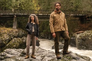 a man laces up a pair of brown hunting boots with a moc toe design