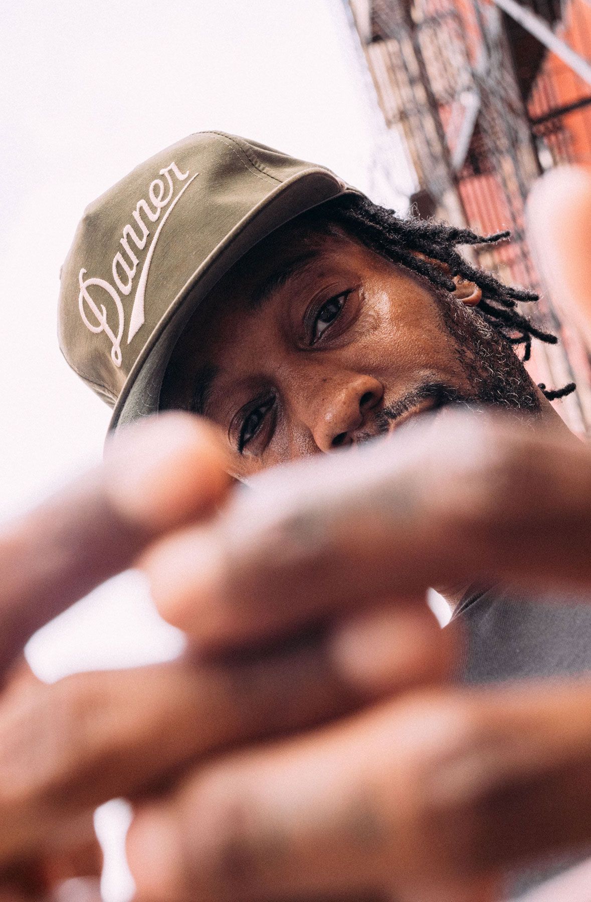 A man hiking through an open field with rocks in the background