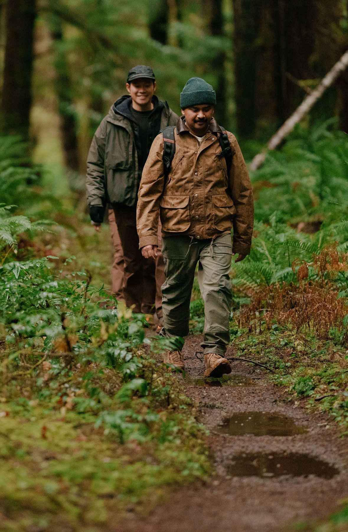 A woman hiking through an open field with rocks in the background