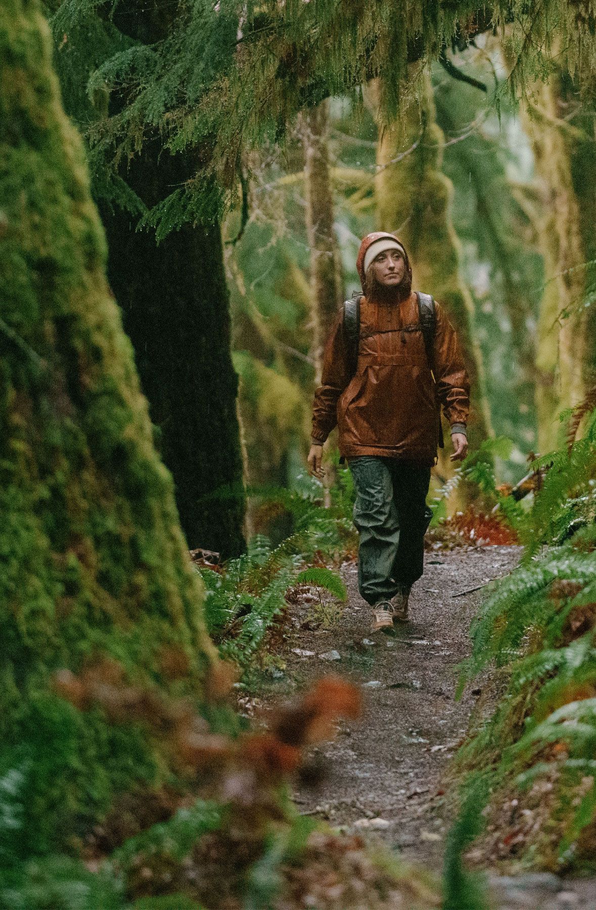 A woman hiking through an open field with rocks in the background