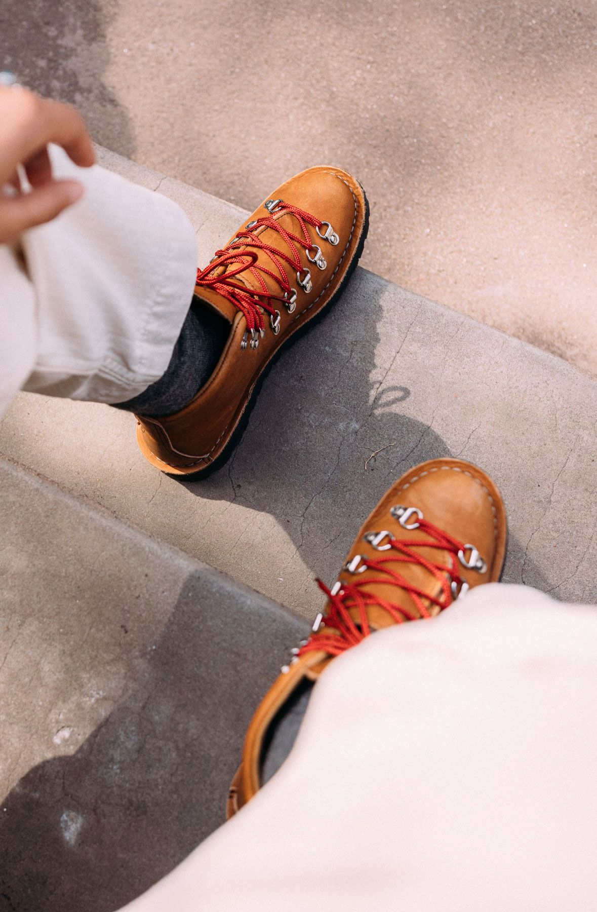 A man hiking through an open field with rocks in the background