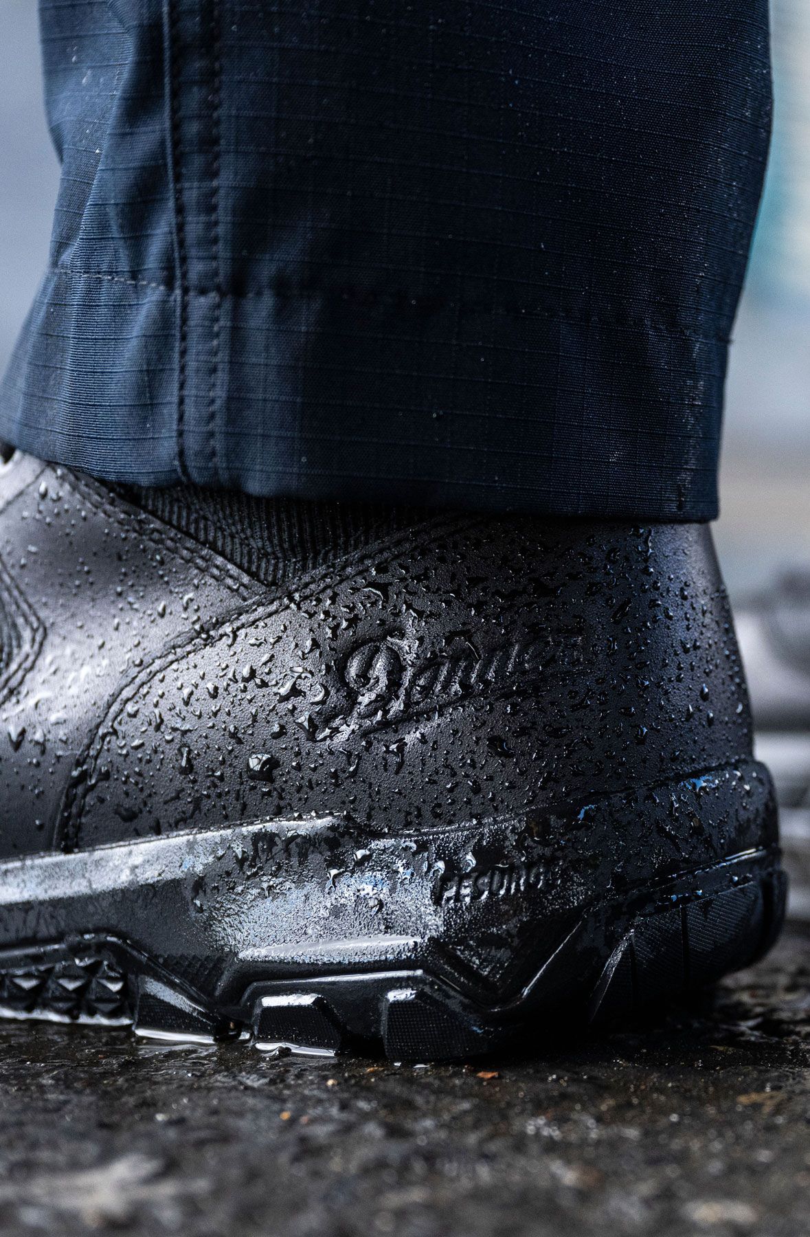 A man hiking through an open field with rocks in the background