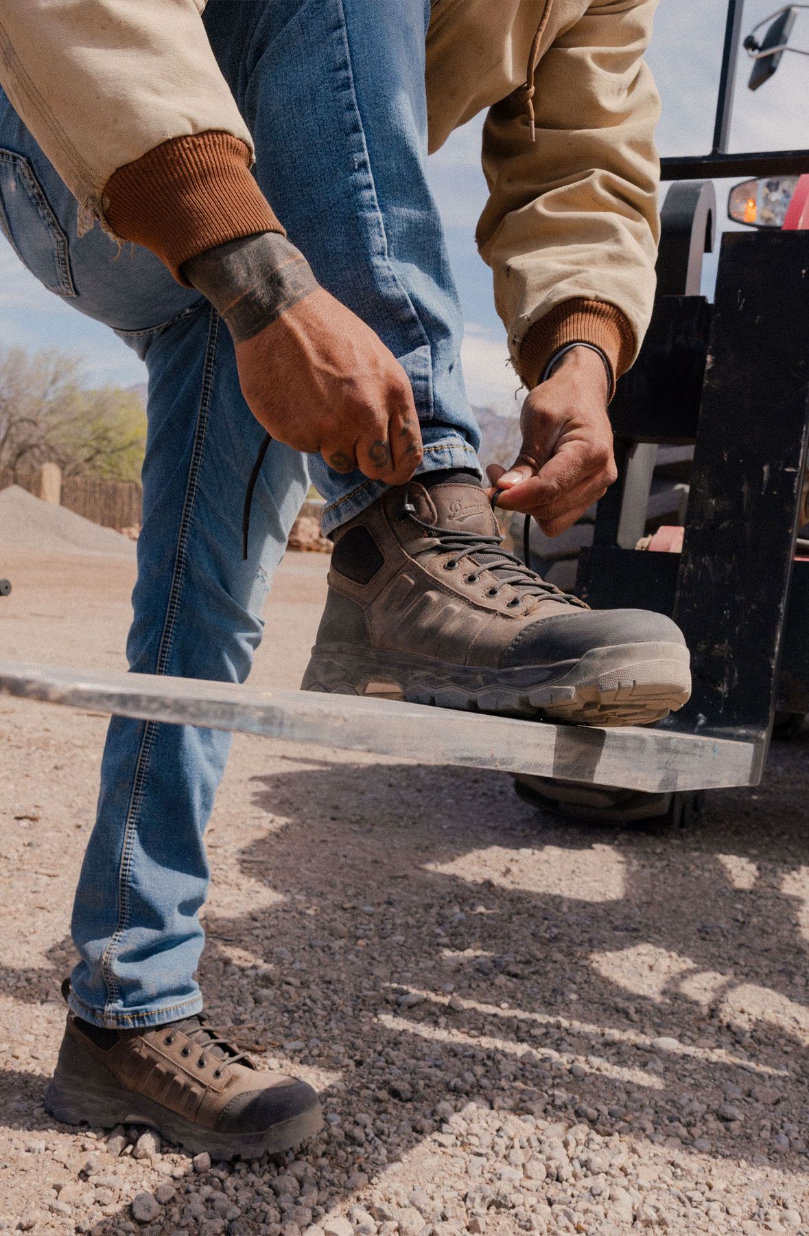 A man hiking through an open field with rocks in the background