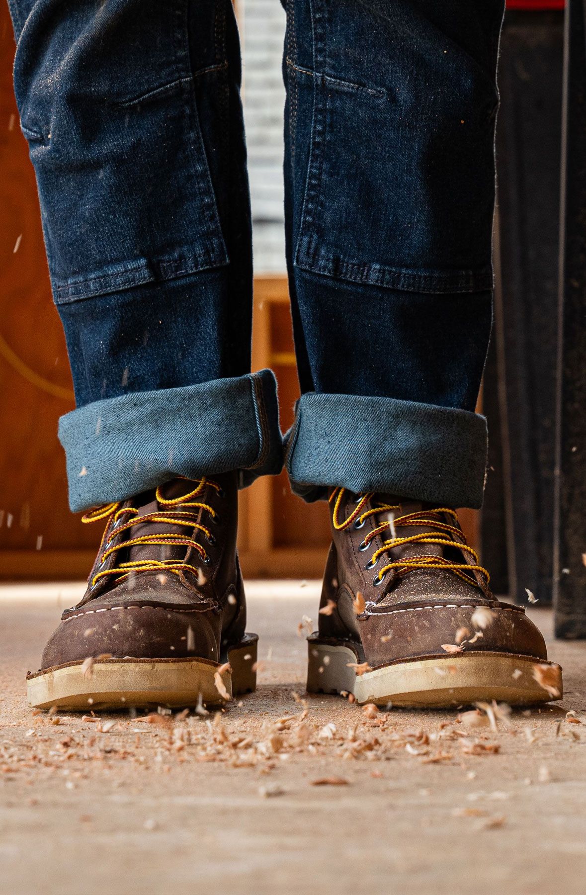 A man hiking through an open field with rocks in the background