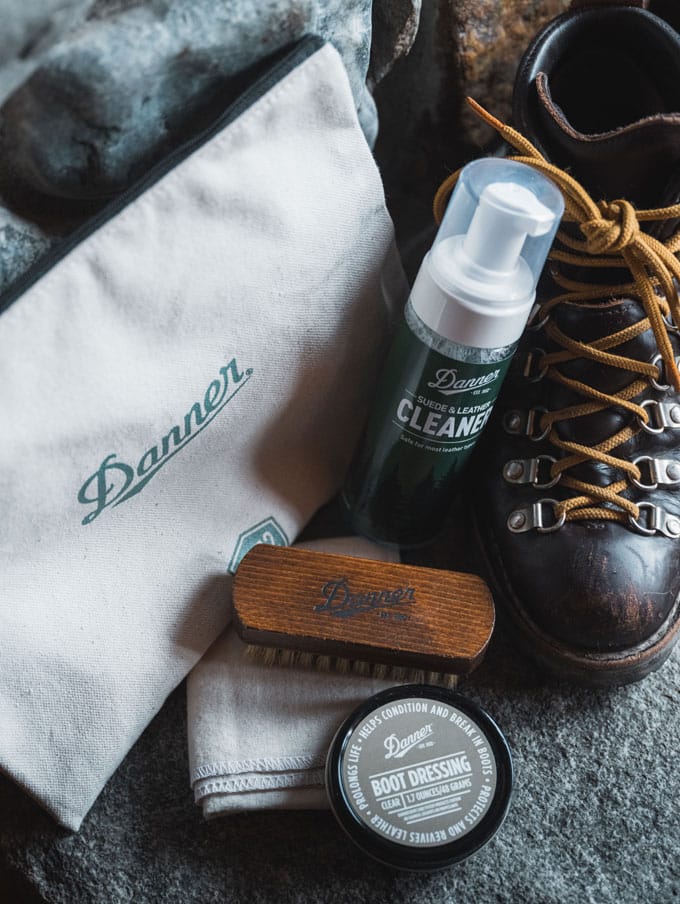 A person walks briskly up a metal staircase wearing polished black leather uniform boots and black pants