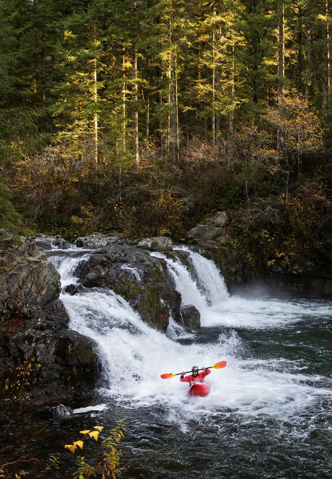 kayaker at the bottom of a waterfall