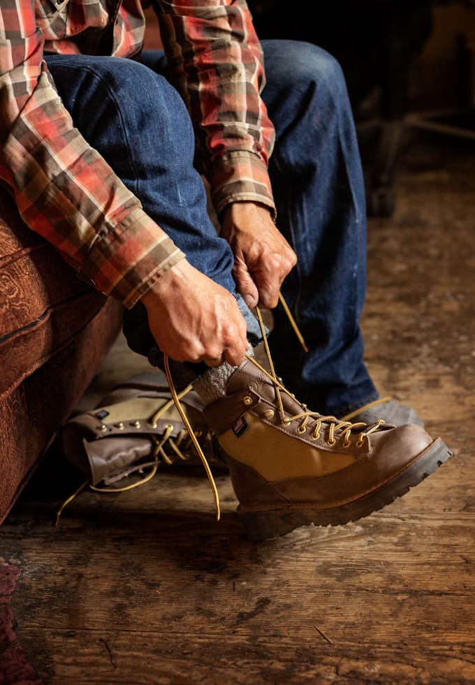 lacing up a pair of brown and tan leather hiking boots