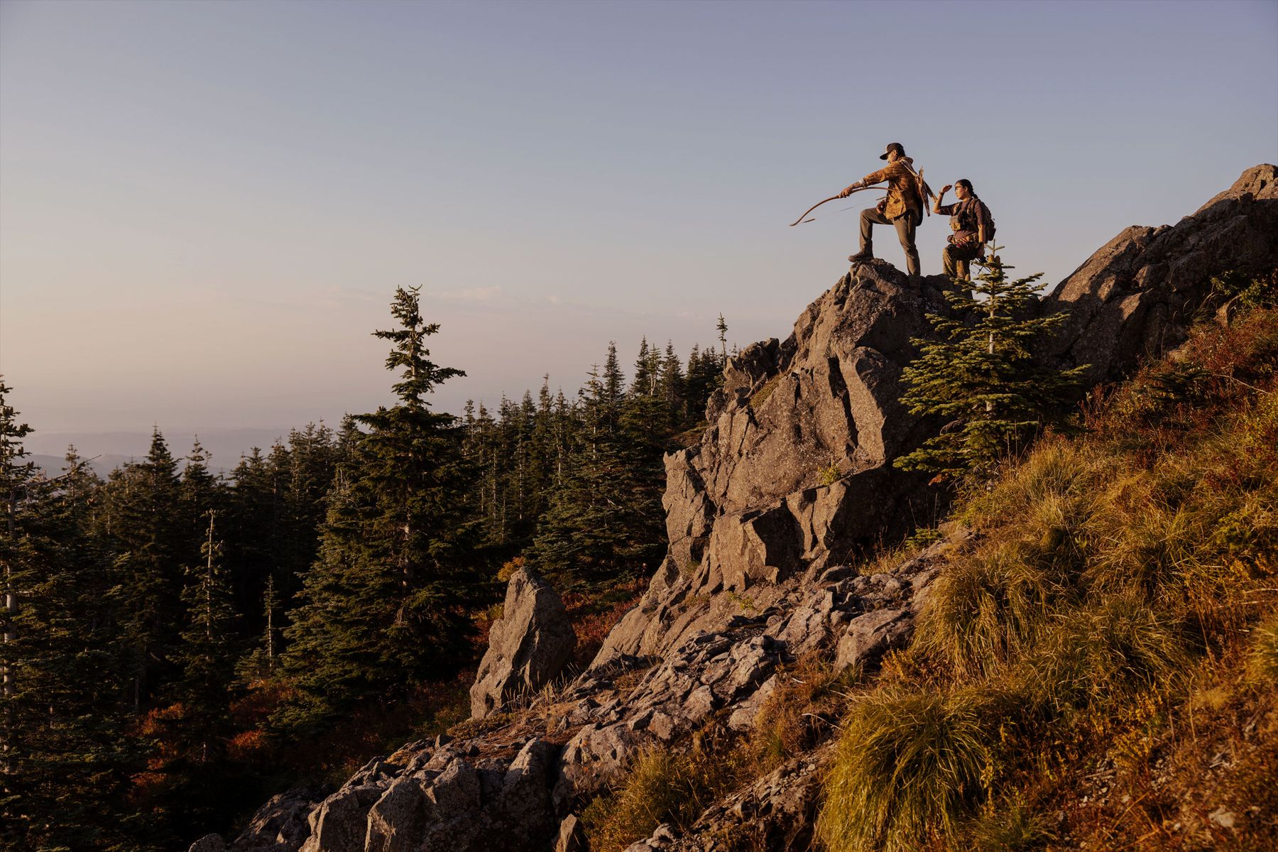 an archer surveys the land from a rock