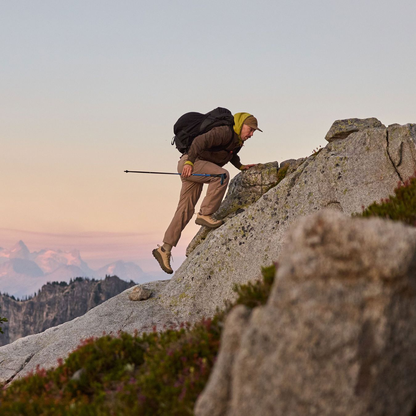 A hiker ascending some rocks in a low top hiking shoe