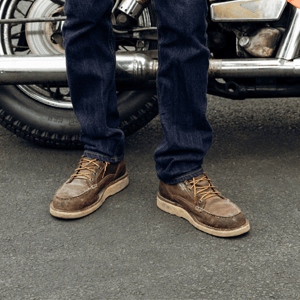 a pair of brown work boots with orange accents