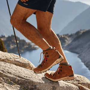 a pair of brown work boots with orange accents