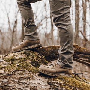a pair of brown work boots with orange accents