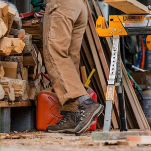 a pair of brown work boots with orange accents