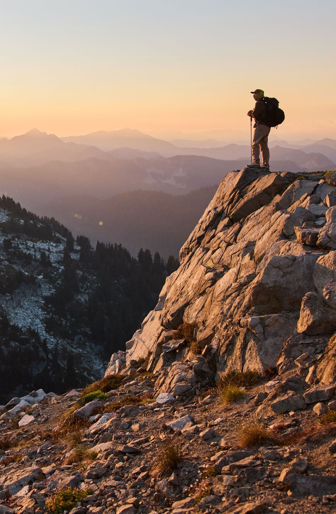 man in hiking boots ascends rocks