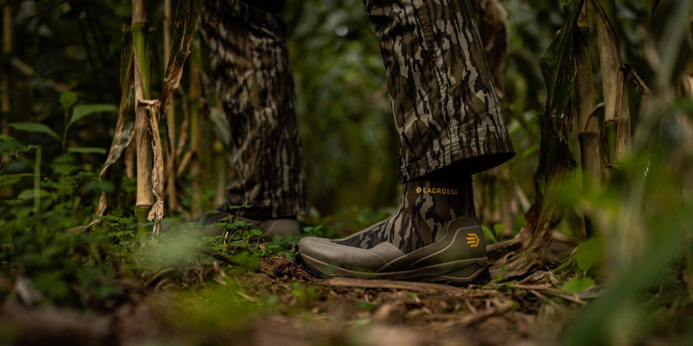 A man in gray boots ascending a tree