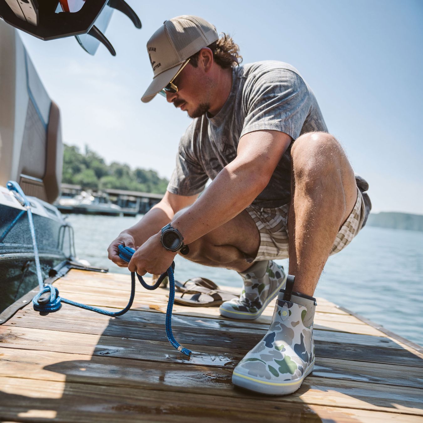 a man wearing short rubber boots in a duck camo