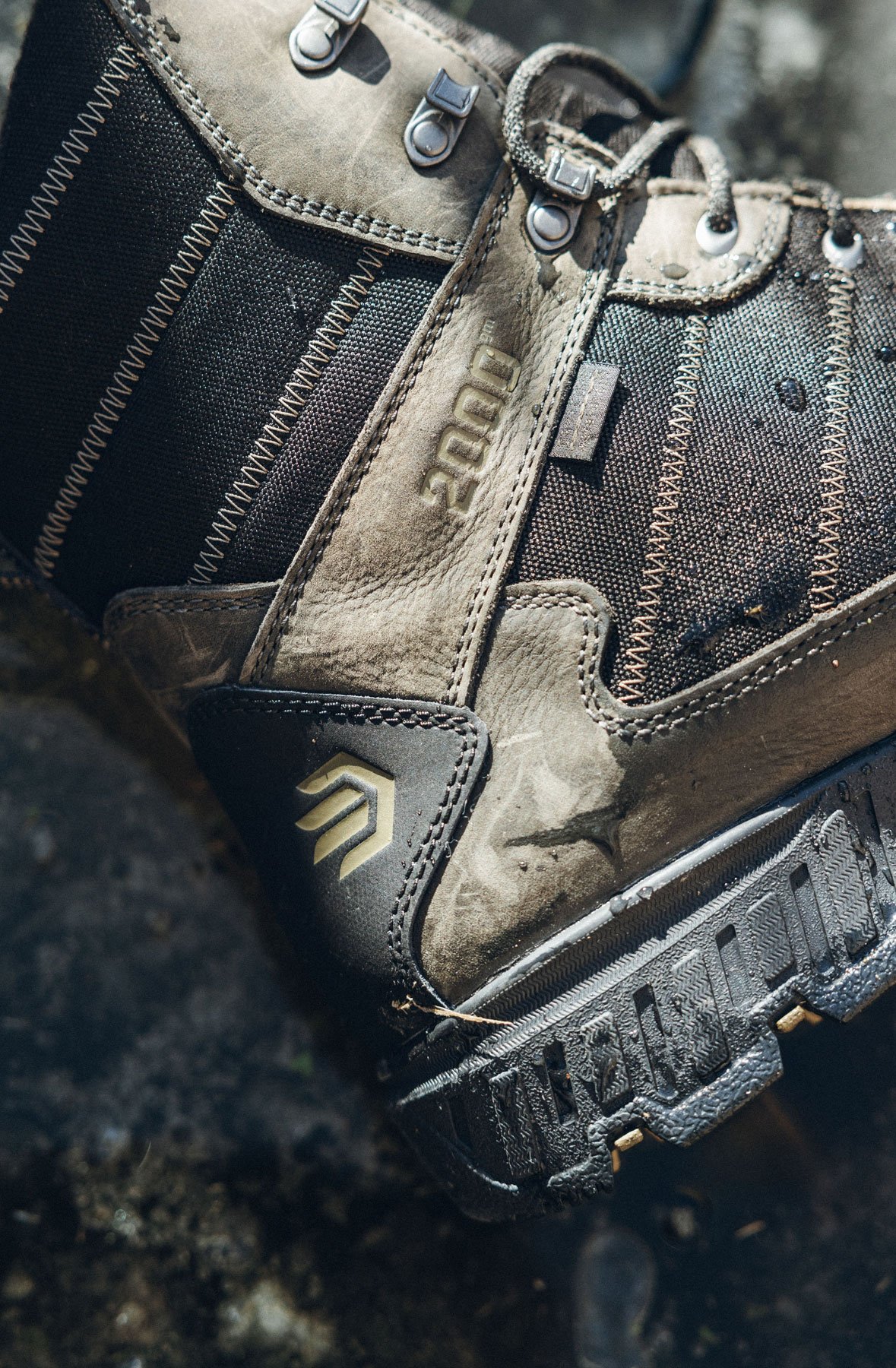 A man in gray boots ascending a tree