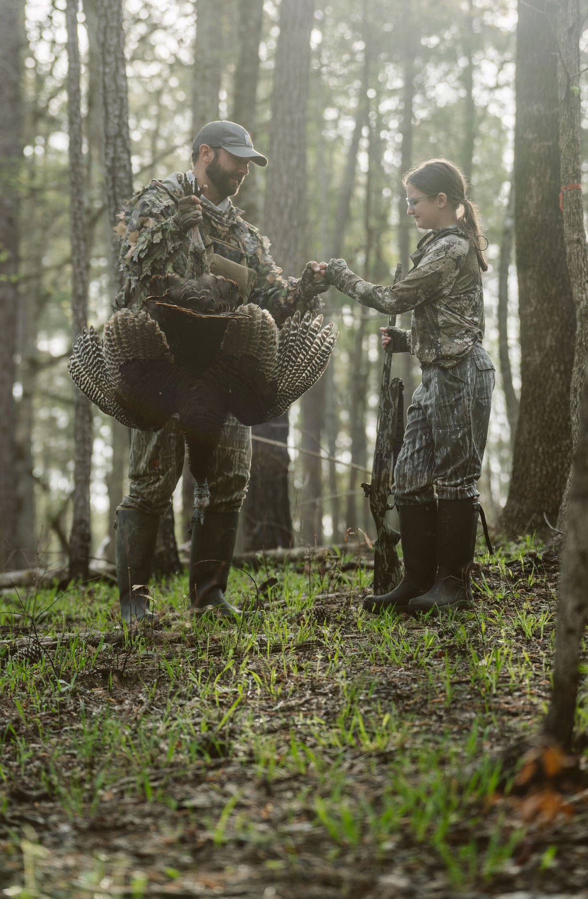 A man in gray boots ascending a tree
