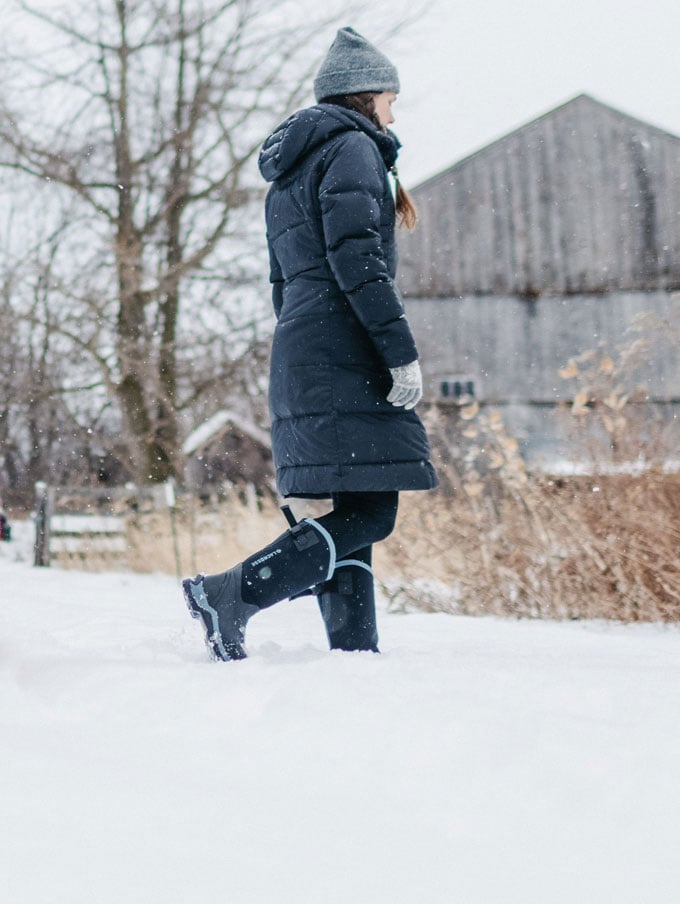 A stone colored pair of ankle high rubber boots is shown getting into a vehicle