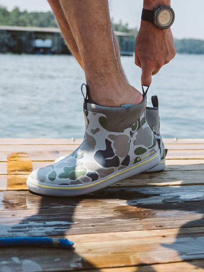 A stone colored pair of ankle high rubber boots is shown getting into a vehicle