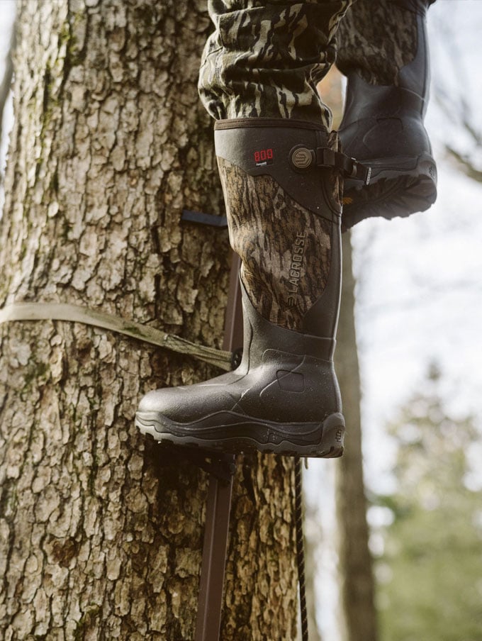 A stone colored pair of ankle high rubber boots is shown getting into a vehicle