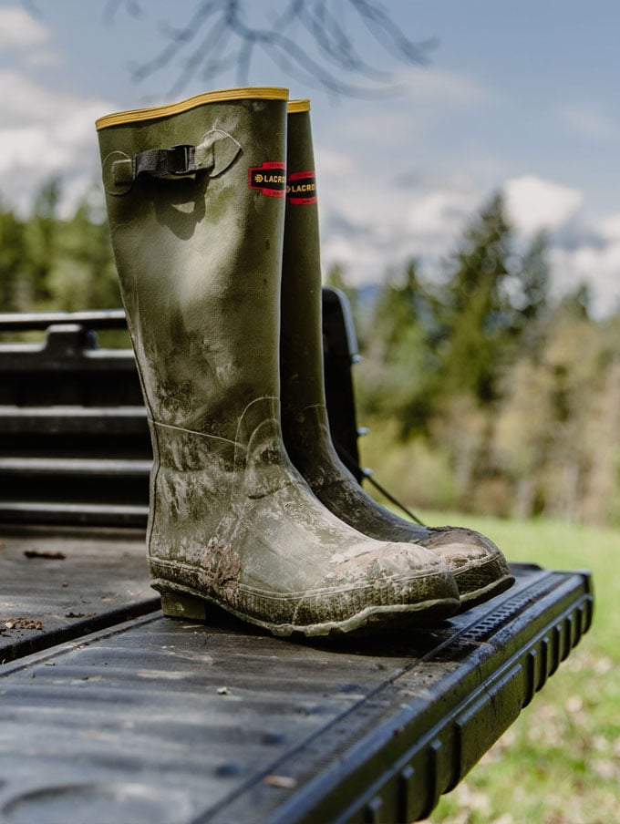 A stone colored pair of ankle high rubber boots is shown getting into a vehicle