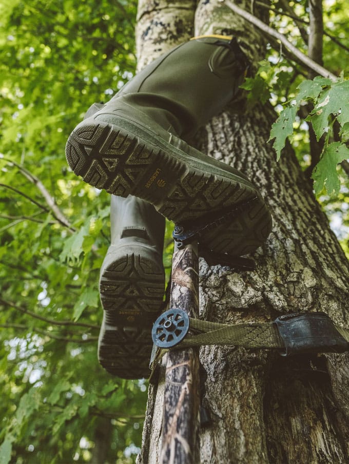 A stone colored pair of ankle high rubber boots is shown getting into a vehicle
