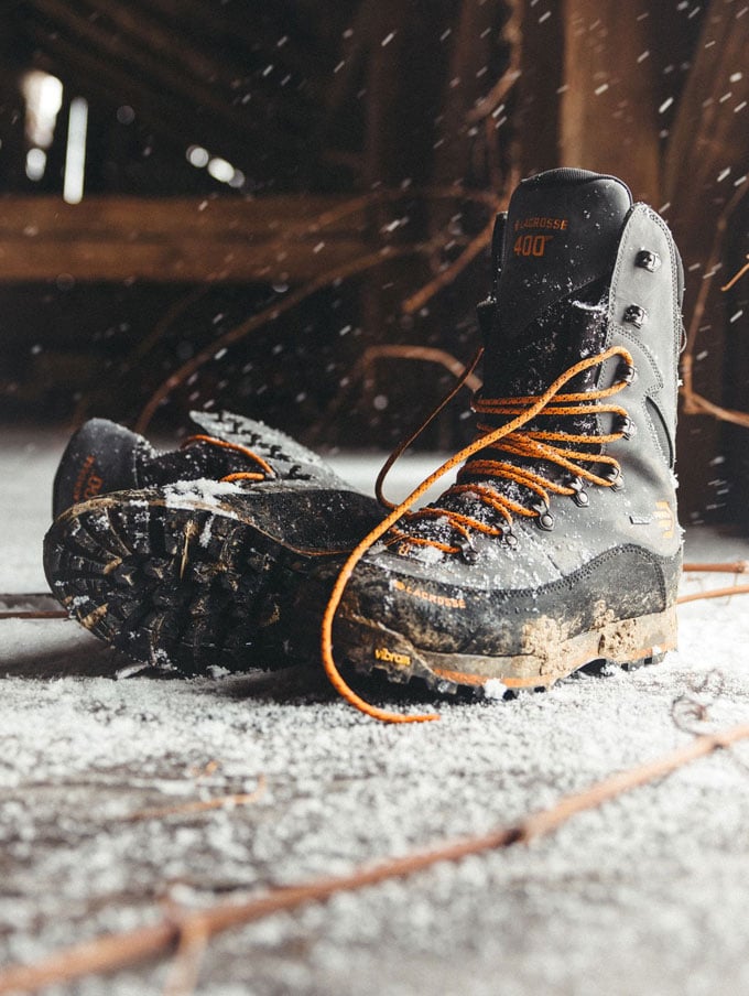 A stone colored pair of ankle high rubber boots is shown getting into a vehicle