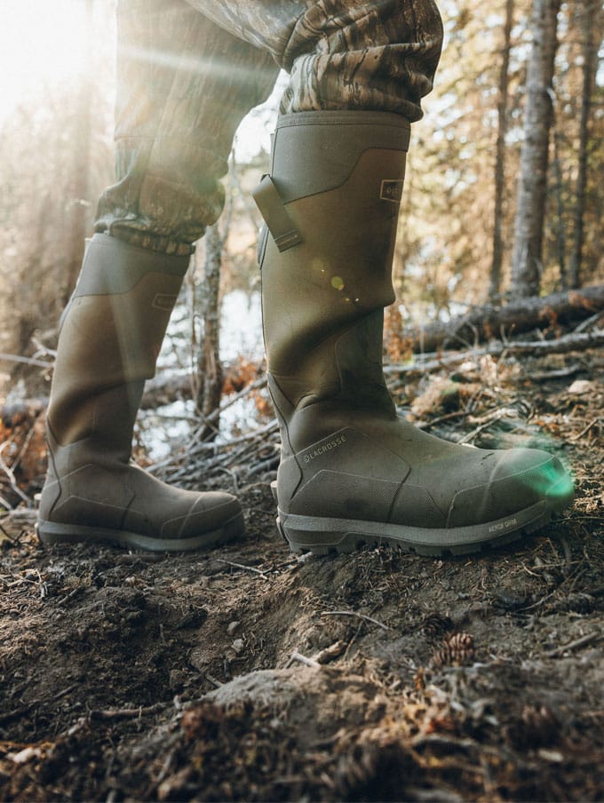 A stone colored pair of ankle high rubber boots is shown getting into a vehicle
